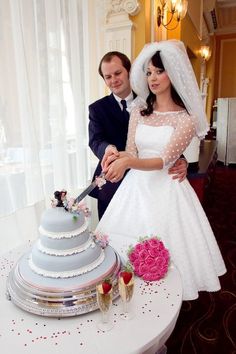 a newly married couple cutting their wedding cake