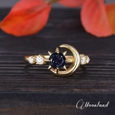 a gold ring with a star and moon on the side, surrounded by three diamonds