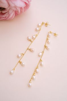 Add a touch of graceful elegance to your bridal look with the Whispering Pearl Drop Earrings! These stunning dangle earrings feature freshwater pearls delicately hanging from a fine gold chain, creating a perfect balance of timeless beauty and modern sophistication. Why do we love them? They’re the perfect blend of chic and classic beauty, making them a must-have for your special day! EARRING FEATURES Material: Brass, Freshwater Pearls Dimensions/Size: 3.2" drop Finish: Polished 14k Gold Plating Dainty Pearl Charm Linear Earrings For Wedding, Elegant Drop Pearl Earrings In 14k Gold Filled, Dainty Pearl Drop Linear Earrings, 14k Gold-filled Pearl Pendant Earrings For Wedding, Delicate Pearl Charm Linear Earrings For Weddings, Pearl White Linear Dangle Earrings With Pearl Charm, Delicate Pearl Charm Drop Bridal Earrings, Delicate Pearl Charm Drop Earrings For Bridal, Elegant 14k Gold Filled Pearl Drop Earrings