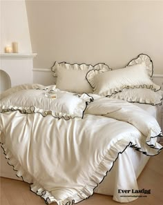 a bed with white sheets and ruffled edges in front of a window, next to a fireplace