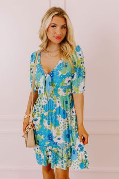 You will be the buzz of the town when you arrive in this pretty blue dress featuring lightweight breezy material patterned with a teal, green, and white floral print, a v-cut neckline with a front tie detail, loose half sleeves, and a relaxed skirt silhouette that falls into a straight mid-thigh length hemline! on products Measurements S : Bust 34", Hip 38", Length 36", Sleeve Length 12.5", Waist 28-30". M : Bust 36", Hip 40", Length 36", Sleeve Length 13", Waist 30-32". L : Bust 38", Hip 42", L Blue Floral V-neck Dress For Vacation, Blue V-neck Mini Dress With Tie Waist, Blue V-neck Mini Dress With Tie Back, Blue Summer Mini Dress For Garden Party, Summer Mini Dress For Garden Party In Blue, Blue Floral Print Sundress, Blue Printed Floral Dress For Garden Party, Blue Breezy Dress For Garden Party, Blue Floral Print Mini Dress For Day Out