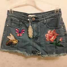 These Jean Shorts Are Very Cute With Bee And Flower Patches. High Rise Summer Bottoms With Floral Embroidery, Casual Blue Bottoms With Floral Embroidery, Cute High Waist Bottoms For Spring, Blue Floral Embroidered Bottoms For Summer, Blue Floral Embroidered Bottoms For Spring, Blue Floral Embroidery Bottoms For Spring, Spring Denim Blue Shorts With Floral Embroidery, Casual High Rise Shorts With Floral Embroidery, Casual High Rise Bottoms With Floral Embroidery