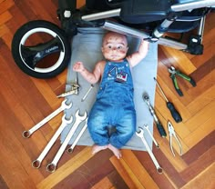 a baby is laying on the floor surrounded by tools