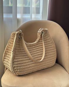 a beige purse sitting on top of a chair