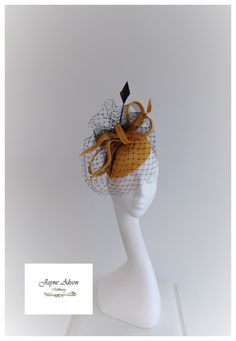 'Simple elegance is captured with this teardrop base in gold sinamay, which is adorned with bows and loops of sinamay bias and black crin.  Black veiling captures a mysterious look whilst a single arrow head feather reaches for the sky.  Sits on a headband This item has sold, however, similar pieces can be made in a variety of colours.  Please ask for details.  As every piece is handmade, some differences can occur from the photos listed on this site.  Made to order/bespoke/custom orders are non Gold Structured Crown Hat For Evening, Gold Hat With Structured Crown For Evening, Gold Adjustable Fascinator With Structured Crown, Fitted Gold Fascinator With Curved Brim, Gold Fitted Fascinator With Curved Brim, Gold Costume Hat With Short Brim For Kentucky Derby, Gold Costume Hats For Kentucky Derby With Short Brim, Gold Curved Brim Top Hat For Party, Gold Hat Fascinator For Royal Ascot