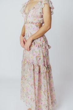 We think the gorgeous Millie Maxi Dress from ASTR is fit for a princess. It's all flowers and ruffles and utterly romantic, perfect for a special vacation dinner, or for when you want to RSVP "elegant" to a spring wedding or shower. This dress doesn't skimp on the feminine details, and deserves a place of honor in your closet! FIT: Runs true to size. Bust is fitted, with a low neckline and bodice cut-outs. MATERIAL: GARMENT DETAILS: Floral chiffon maxi dress, with a plunging V-neckline, multi-tiered ruffled sleeves, and side cut-outs under the bust. Features a full, flowy skirt with ruffle accents, a smocked back panel, and a back self-tie detail at the shoulders. SIZE GUIDE: XS (00-0) / S (2-4) / M (6-8) / L (10-12) MODEL DETAILS: ﻿Heather is wearing size S. Mackenzie - Size S Heather - S Elegant Floral Print Maxi Ruffle Dress, Elegant Maxi Length Floral Print Ruffle Dress, Chic Floral Print Ruffle Dress For Garden Party, Feminine Floral Dress With Ruffled Straps For Garden Party, Flirty Dresses With Ruffled Straps For Garden Party, Floral Print Maxi Length Ruffle Dress For Garden Party, Feminine Floral Dress With Ruffled Straps, Feminine Ruffle Hem Dress For Garden Party, Elegant Floral Maxi Dress With Ruffles