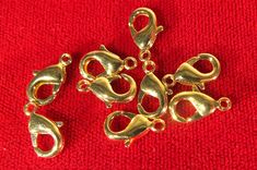 gold plated charms on red cloth with clippings for clasps or necklaces