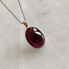 ITEM DESCRIPTION: >> The Pendant is made from Solid 14K Yellow Gold. Gemstone used is absolutely natural and ethically sourced. >> Natural Garnet in cabochon cut and oval shape with bezel setting is studded on it with utmost precision. >> This is a minimalist design and is absolutely hassle-free and everyday jewelry. Gem: Garnet Gem size: 14x19 mm oval Gem weight: 20.66 carats Gold purity: 14K (58.33% approx.) Gold weight: 0.62 grams Gross weight: 4.75 grams The Gold purity is guaranteed and it Garnet Pendant Necklace, Gold Oval Garnet Necklaces, Yellow Gold Gemstones With Bezel Setting, Yellow Gold Garnet Necklaces With Oval Shape, Elegant Birthstone Jewelry In Oval Cabochon, 14k Gold Gemstones With Bezel Setting For Gift, Elegant Amber Oval Cabochon Necklace, Formal Garnet Jewelry With Bezel Setting, Oval Garnet Gold Necklace