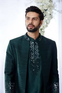 This emerald green open sherwani set features mirror work detailing on the neck and on the cuffs of the sherwani. It compliments the detailing of mirror work yoke of a silk kurta paired with a brocade trouser. Complimenting footwear is also available. From Seema Gujral's Tuscan Summer collection. DELIVERY TIMEPlease allow 8-12 weeks for your outfit to arrive.FABRIC DETAILSRaw SilkProfessional cleaning only. Emerald Green Sherwani, Mirror Work Kurta For Men, Open Sherwani, Brocade Trousers, Tuscan Summer, India Fashion Men, Marriage Dresses, Mens Traditional Wear, Jodhpuri Suits For Men