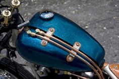 the handlebars and saddlebags on this motorcycle are shiny blue with gold accents