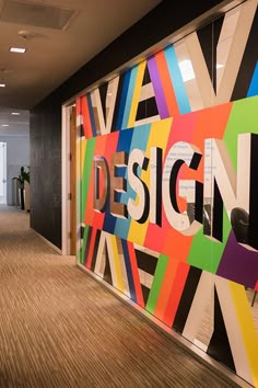 an office lobby decorated with colorful wallpaper and wood flooring that says design on it