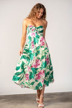 This stunning midi dress boasts a bold and colorful floral print, perfect for making a statement. The strapless design and bare shoulders add an alluring touch, making it a must-have for any sophisticated and stylish wardrobe. Materials: 100% Cotton Sizes: XS, S, M, L Colors: Green/Pink Multi P06 Made in USA Dry clean only Model size: S Style: BNB1906P06 Black Dress Jacket, Junior Girl Dresses, Lavender Brown, Church Fits, Maxi Dress Sale, Stylish Wardrobe, Bare Shoulders, Kids Boutique, Colors Green