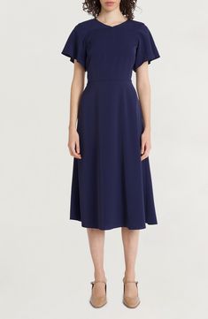 A desk-to-dinner dress is rendered in classic navy and fixed with fluttering sleeves for a dash of added charm. 47 1/2" length Hidden back-zip closure Jewel neck Short sleeves 100% polyester Machine wash, tumble dry Imported Basic Dresses, The Curated Closet, Curated Closet, Dinner Dress, Flutter Sleeve Dress, Basic Dress, Midi Dress With Sleeves, Sleeve Midi Dress, Jewel Neck