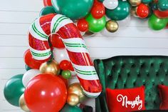 balloons and candy canes are on display in front of a christmas themed wall decoration