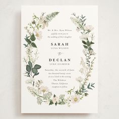 a wedding card with white flowers and greenery