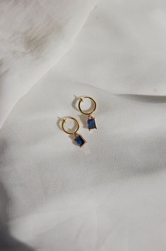 These dainty earrings are made with sapphire rhinestone charms and 18 karat gold plated huggie hoops. This gold plating protects against wear and tear, tarnishing, and light contact with substances such as water. Closures: * Standard gold hoops are hypoallergenic and nickel free (18 karat gold plated). * Clip on gold hoops are hypoallergenic and nickel free (18 karat gold plated). How to wear clip ons: Hold the earring in one hand while pulling the closure open with the other hand, place the ear Blue Huggie Hoop Earrings, Blue Small Hoop Huggie Earrings, Blue Hypoallergenic Small Hoop Huggie Earrings, Hypoallergenic Blue Small Hoop Huggie Earrings, Blue Hypoallergenic Small Hoop Earrings, Blue Dangle Hoop Earrings For Gift, Blue Dangle Hoop Earrings As Gift, Blue Small Hoop Huggie Earrings For Everyday, Blue Hypoallergenic Small Hoop Jewelry