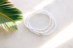 Matte Coconut white seed beads strung on stretch cord finished with a natural sea shell Bracelet can be wrapped around the wrist 3 times. Fits the average sized wrist (7 inches) The string total length is approximately 21 inches. Can also be worn as an anklet or a necklace. If you need a customized length or would like your bracelet to have more layers, please feel free to message me for a custom order! Handmade with love by Amanda 🐚 Surf wave bracelet can be found here: https://etsy.me/2DSXXfa Adjustable White Shell Beaded Bracelet, White Shell-shaped Beaded Bracelets For Vacation, Vacation Ocean-inspired Shell Beaded Bracelets, Sea Shell Bracelet, Beachy Adjustable Shell-shaped Bracelets, Surf Wave, Adjustable Shell-shaped Beach Bracelet, Wave Bracelet, White Sea