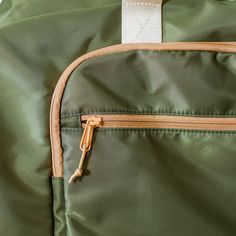 a close up of the zippers on a green backpack