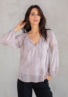 With a classic bohemian silhouette, this dreamy peasant top will be a timeless addition to your closet. Featuring delicate floral embroidery throughout, voluminous long sleeves with lattice trim, and a split v-neckline with tassel ties. We love to style this effortless blouse tucked into trousers or jeans. FINAL SALE Embroidered chiffon Relaxed fit Long voluminous sleeve Elastic wrist cuff Lace-trimmed neckline Split v-neckline with tassel ties Lattice trim throughout Sheer Removable lining Peas Feminine Long Sleeve Peasant Top With Ruffles, Feminine Peasant Top With Balloon Blouson Sleeves, Elegant Peasant Top With Blouson Sleeves For Fall, Flowy Long Sleeve Peasant Top With Ruffles, Flowy Peasant Top With Blouson Sleeves, Feminine Lantern Sleeve Peasant Top For Spring, Elegant Balloon Sleeve Peasant Top, Elegant Spring Peasant Top With Lantern Sleeves, Feminine Long Sleeve Peasant Top For Spring