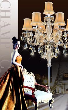 a chandelier that is next to a chair with a lamp on it and a woman in an orange dress