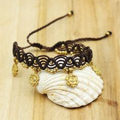 This fancy anklet is in dark brown macramé with small golden brass plates. Its size is adjustable on the ankle thanks to its sliding knot. This anklet can go in water because the brass does not move. You will wear this foot chain on an ethnic, boho or hippie chic outfit. foot chain width 2.5cm Gold Adjustable Friendship Bracelets For Festivals, Gold Friendship Bracelets With Sliding Knot For Festivals, Adjustable Gold Friendship Bracelets For Festivals, Adjustable Gold Friendship Bracelet For Festivals, Bohemian Gold Bracelet With Adjustable Cord, Bohemian Gold Resizable Friendship Bracelets, Gold Bohemian Resizable Friendship Bracelets, Beach Jewelry With Brown Tassels, Bohemian Gold Bracelet With Adjustable Length