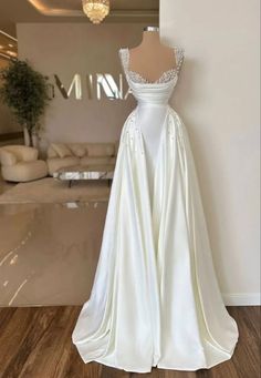 a white wedding dress on display in a room