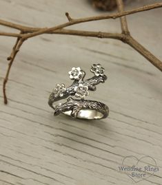 Exclusive floral designed ring for woman, Flowers on a branch ring, Nature sterling silver ring, Unique twig ring with gems, Wide gift ring ■ All wedding rings are only crafted with the finest of recycled metals DETAILS: Stones - 1,5mm Cubic Zirconia (4pcs) Metal - Sterling Silver Dimensions - width 22mm (0.86 in.), band width - 3mm (0.118 in.) Finish - shiny and oxidized (shiny at your request - shown in the last photo) Please choose your ring size and gems in menu while making your order View Dainty Jewelry For Spring Anniversary, Dainty Jewelry For Anniversary In Spring, Dainty Spring Jewelry For Anniversary, Delicate Jewelry For Spring Anniversary, Delicate Jewelry For Anniversary In Spring, Delicate Spring Jewelry For Anniversary, Silver Whimsical Jewelry For Promise Ring, Elegant Sterling Silver Spring Jewelry, Whimsical Silver Promise Ring Jewelry