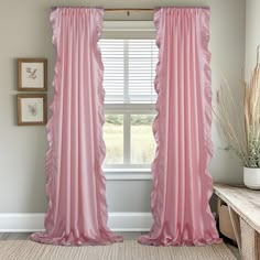 a pink curtain with ruffled edges hangs in front of a window, next to a bench