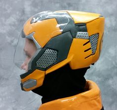 a close up of a person wearing a helmet and protective gear on their head with a gray background