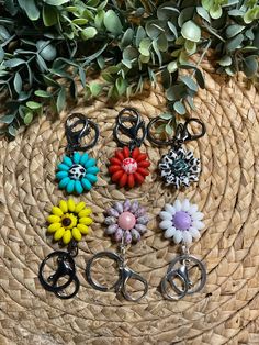 six flower shaped key chains sitting on top of a woven basket