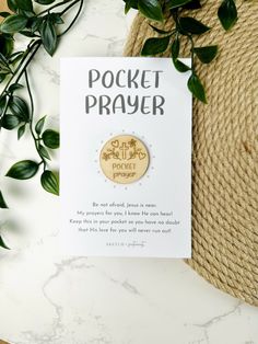 the pocket prayer card is next to a plant