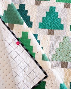 a close up of a quilt with green and white squares on it's edges