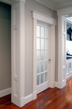 an empty room with wood floors and white doors