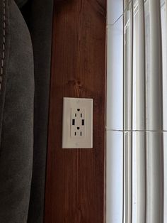 an electrical outlet on the side of a wooden wall