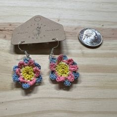 Add a touch of whimsical charm to your style with these stunning handmade earrings. Each earring features a delicate micro-crocheted flower motif, crafted with precision and care. The flowers showcase a vibrant pink and blue palette with a cheerful yellow center, creating a beautiful contrast that stands out. Lightweight and comfortable, these earrings are perfect for everyday wear or special occasions. Their unique design and intricate detailing make them a delightful addition to any jewelry collection. Whether you're dressing up or keeping it casual, these earrings will add a splash of color and a hint of playful elegance to your look. Pink Crochet Dangle Jewelry, Whimsical Handmade Earrings For Everyday, Handmade Whimsical Dangle Flower Earrings, Handmade Small Adjustable Earrings, Handmade Adjustable Small Earrings, Cute Small Handmade Earrings, Cute Handmade Drop Earrings, Everyday Bohemian Dangle Flower Earrings, Crochet Flower-shaped Earrings For Gift