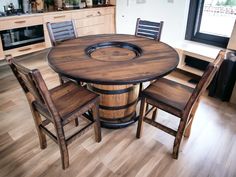 a wooden table with chairs around it in a kitchen