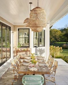 an outdoor dining area with wicker chairs and wooden table on the front porch next to sliding glass doors