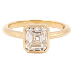 an emerald cut diamond ring in yellow gold with a single stone on the front and side