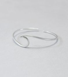 Wave cuff bangle, sterling silver, beach jewellery, ocean, beach bracelet, minimalist, adjustable, gift for her, one size Sterling silver solid cuff hand formed to a wave shape from 12 gauge (2 mm) wire. Comfortable to wear all day or sleep with and sturdy. This bangle is slightly adjustable and thus one size. It will fit most wrists (14 -18 cm / 5.5 - 7 inches wrist). But you can always ask for a different size. The bracelet above is not the exact one you will receive. Each one is handmade to o Silver Dainty Bracelets For Beach, Silver Minimalist Bracelets For The Beach, Dainty Silver Bracelets For The Beach, Silver Minimalist Resizable Bracelet, Minimalist Silver Resizable Bracelet, Minimalist Beach Bracelet Jewelry, Minimalist Beach Bracelets, Minimalist Sterling Silver Jewelry For Beach, Dainty Adjustable Sterling Silver Bangle