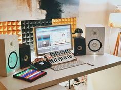 there is a computer on the desk with speakers next to it and a keyboard in front