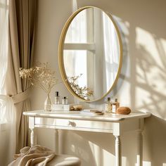 a white vanity with a round mirror on the wall next to it and flowers in vases