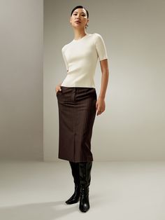 Our stylish high-waisted midi pencil skirt with timeless appeal is tailored from lightweight tweed made from a breathable silk-wool blend, which ensures both sustainability and luxurious quality. Cut from a textured fabric with white vertical pinstripes, it has a length below the knee and a front slit for added femininity and ease. Boasting a flattering, figure-hugging silhouette, its clean-cut lines and pinstripe design elongate while lending an undeniable sophistication to your look. The versa Airport Outfits, Midi Pencil Skirt, High Waisted Pencil Skirt, Midi Skirt Pencil, Winter Fun, Professional Look, Airport Outfit, Winter Dresses, Concert Outfit