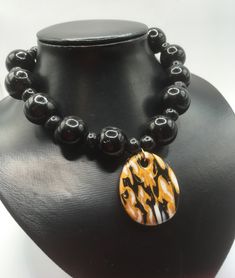 I've used the Japanese mokume gane technique to create this polymer clay pendant. It comprises gold, black and white polymer clay. The pendant has been teamed with chunky black glass beads and smaller wooden beads.  I chose white beads so that the marbled pendant would really stand out. (And I'm a big fan of the chunky!) The necklace is closed with a lobster claw lock and extends to 49cm maximum with use of the extender chain. Use the lobster claw to meet the length that best suits you. The pend Black And White Polymer Clay, White Polymer Clay, Marbled Clay, Mokume Gane, Necklace Chunky, Polymer Clay Pendant, Black Necklace, Handmade Clay, Bead Jewellery