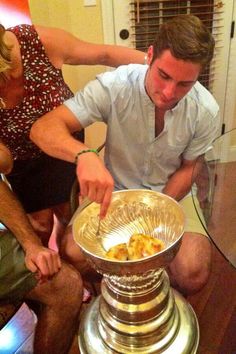 a man sitting on the floor next to a woman in front of a cake stand