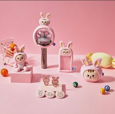 an assortment of toys on a pink surface with one toy in the center and two bunny figures around it