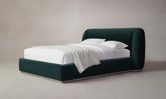 a bed with white sheets and green headboard on it's side, against a gray background