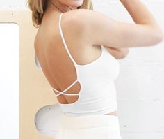 Low back cropped cami with criss-cross detail. COLORS: Melon; Yellow; White Made in USAFabric: 92% Nylon / 8% Spandex One size fits most. Chic Crop Top With Built-in Bra And Strappy Back, Casual Crop Top With Built-in Bra And Strappy Back, Spring Strappy Sports Bra With Built-in Bra, Fitted Top With Seamless Construction And Cross Back, White Fitted Cross Back Top, Spring Cropped Sports Bra With Built-in Bra, Cropped Stretch Sports Bra With Straps, Fitted Cross Back Top With Crisscross Straps, Fitted Cross Back Tank Top With Built-in Bra