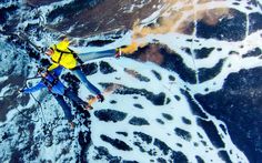 an aerial view of two people on skis in the snow