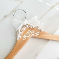 a wooden hanger with the word mr and mrs written on it next to a pair of earrings