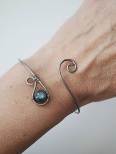 a woman's arm with a wire wrapped around it and a stone in the middle